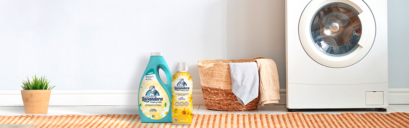 Detergente y suavizante la lavandera al lado de un lavadora