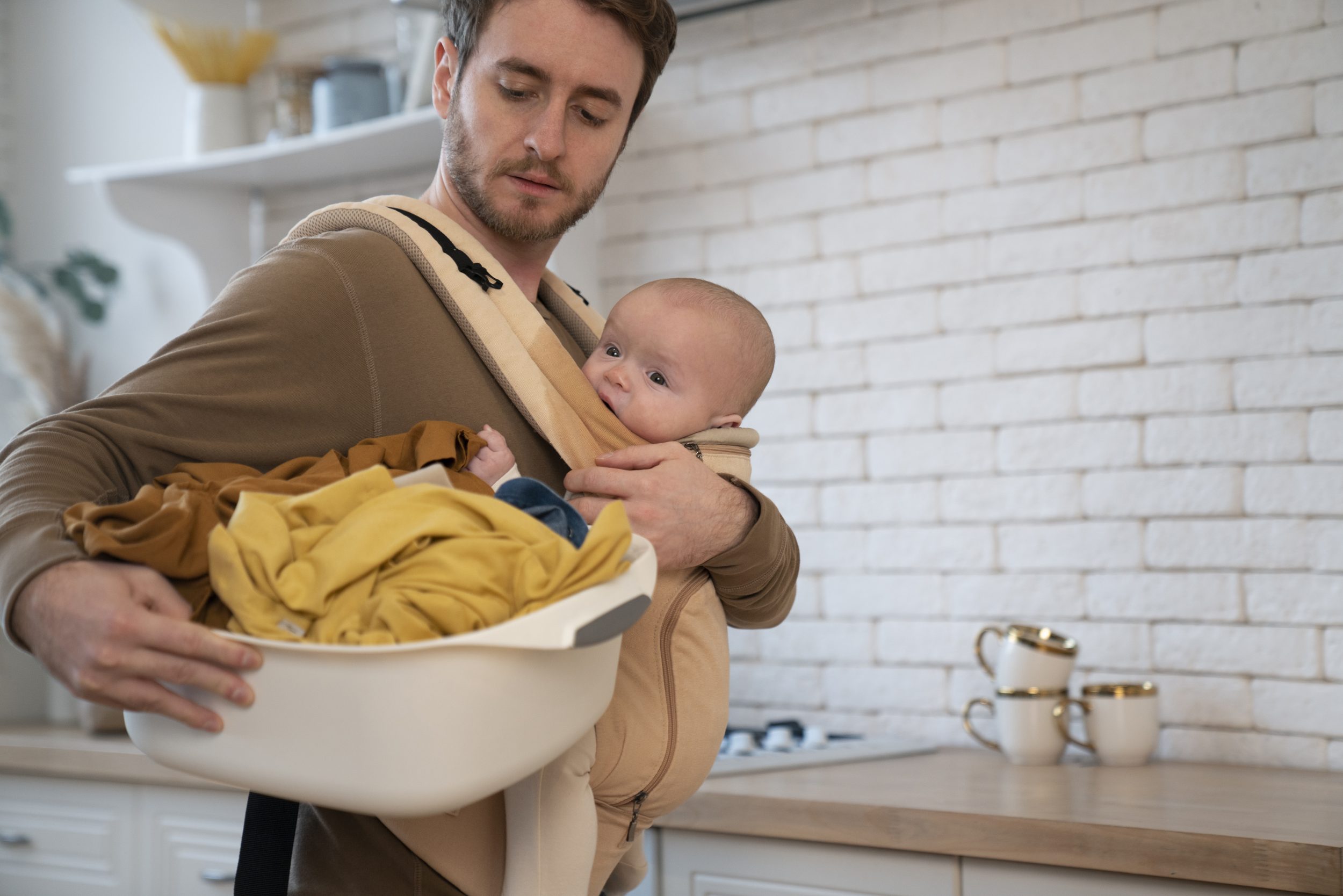 Padre haciendo colada de la ropa de bebé