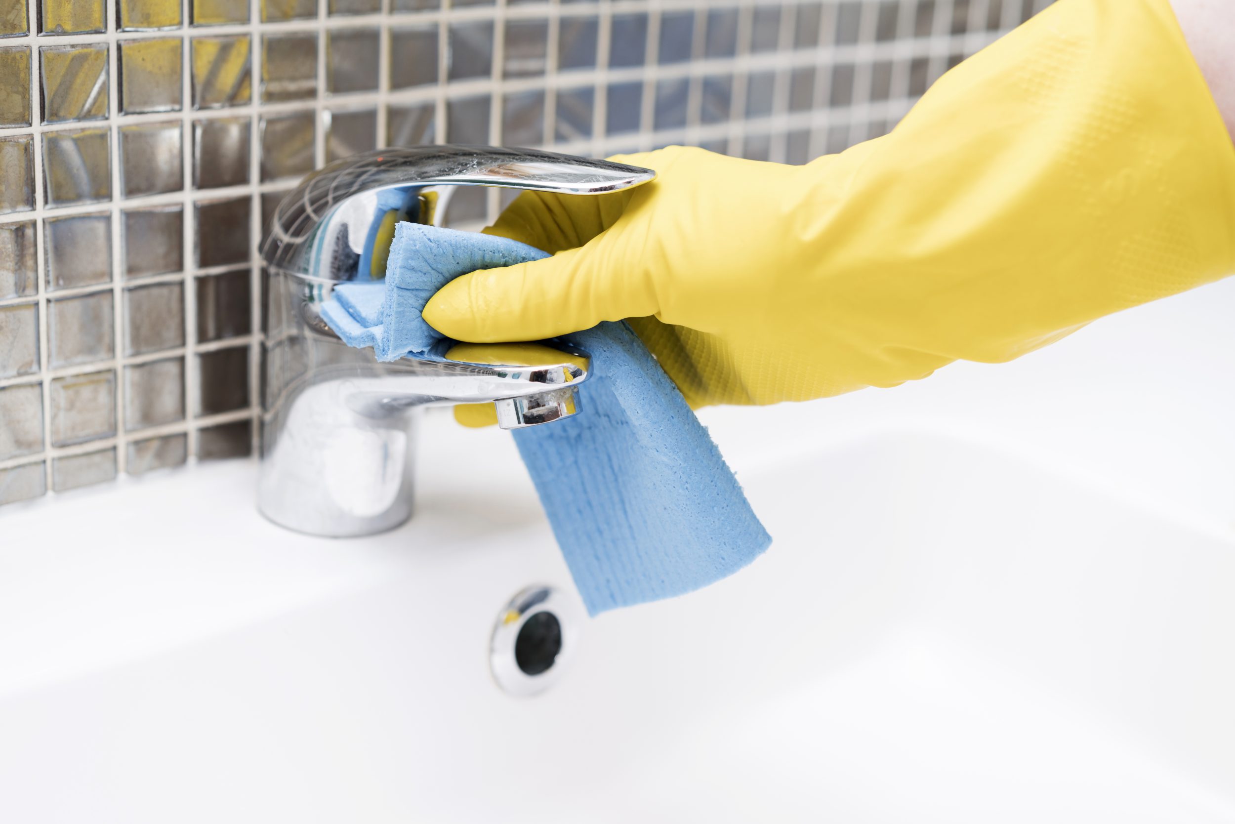 Persona limpiando grifo baño