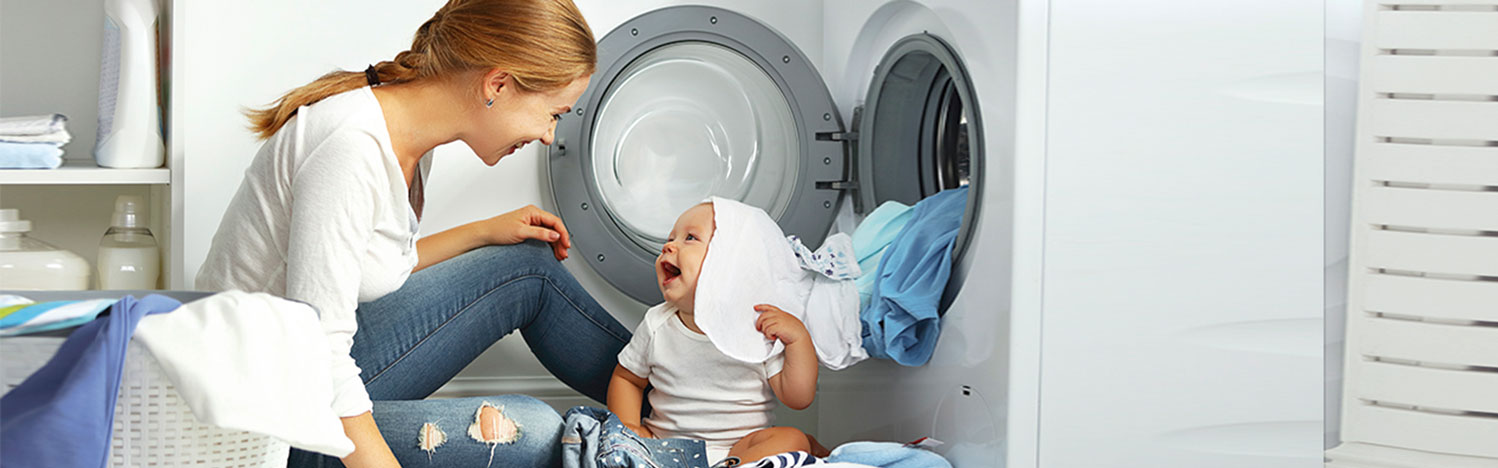 Mujer poniendo la lavadora con su hijo