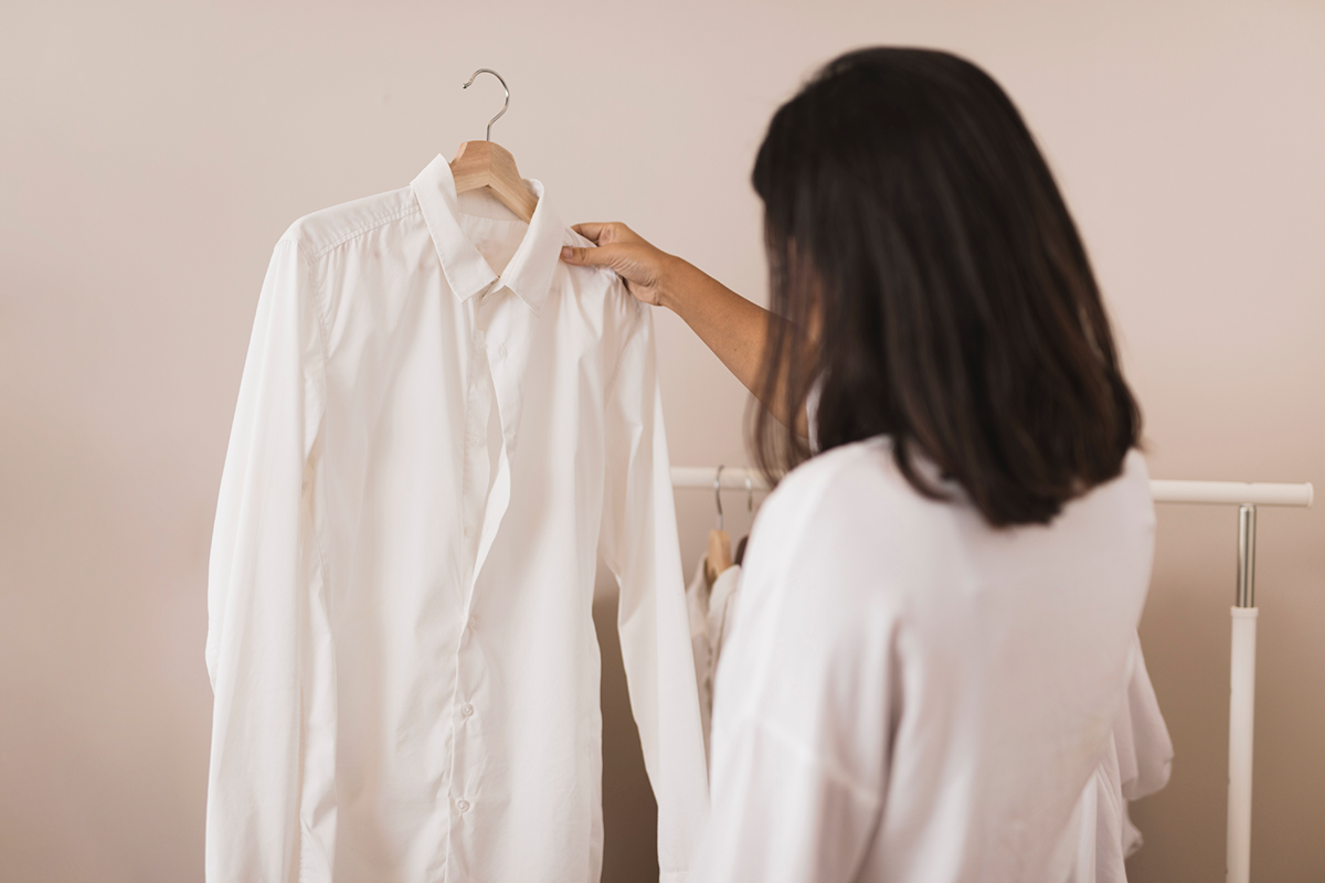 Mujer mirando una camisa blanca recién lavada