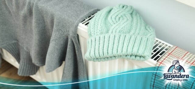 ropa de lana secándose encima de un radiador con el logo de la lavandera