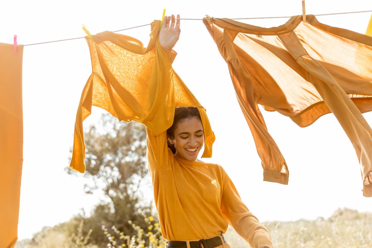 Mujer Sonriente Con Ropa De Lino De Color Naranja Secandose Atras