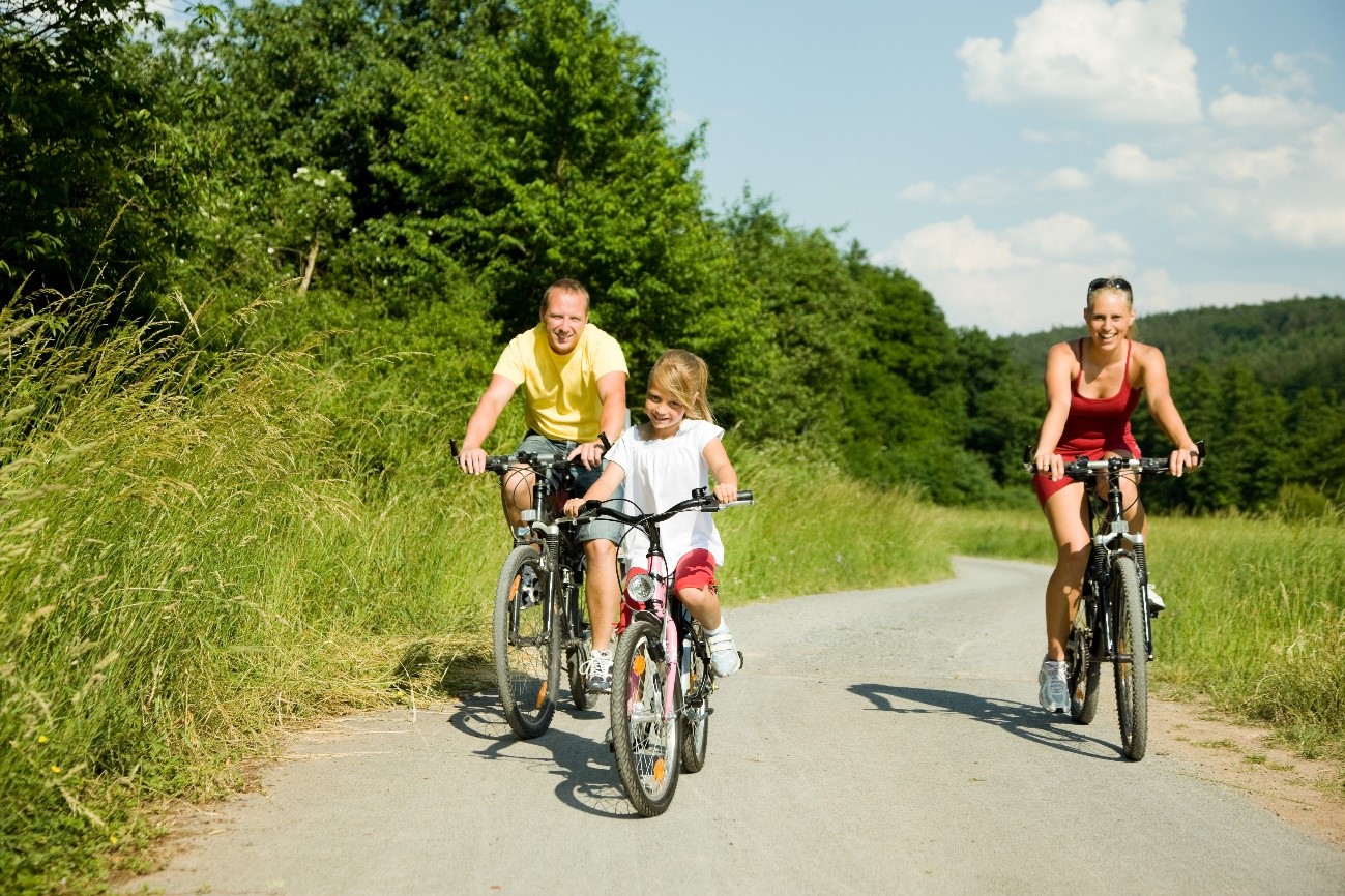 familia montando en bici en un entorno natural durante un día soleado